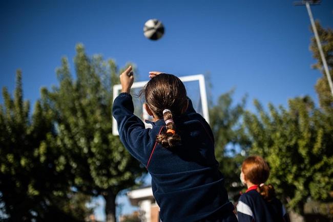 Dos niñas jugando en el patio de un colegio.