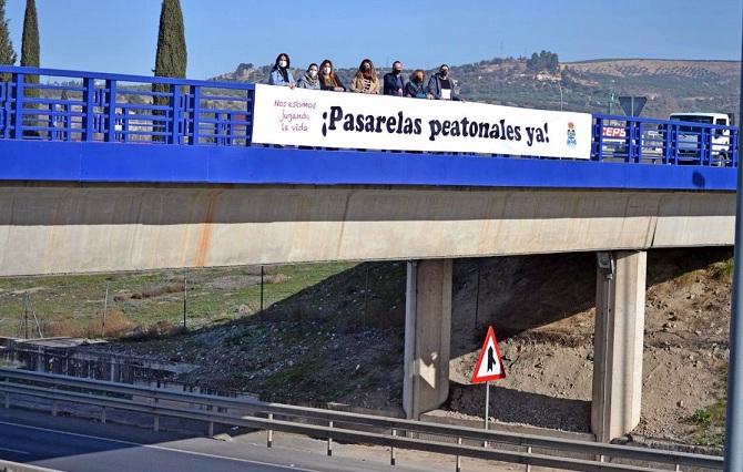 Pancarta sobre la autovía que pide pasarelas peatonales. 