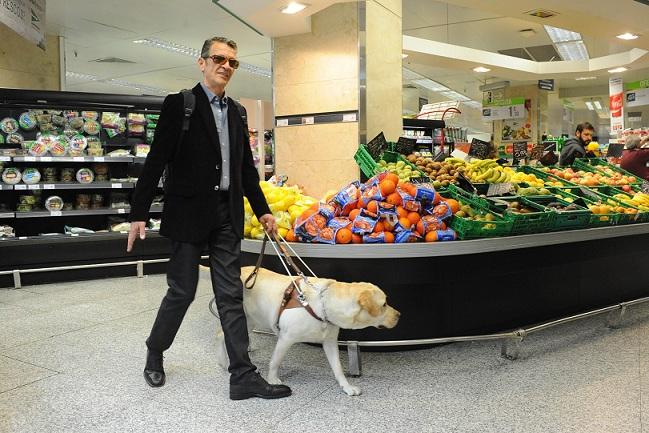 Una persona ciega con su perro guía en un supermercado, en una imagen de archivo.
