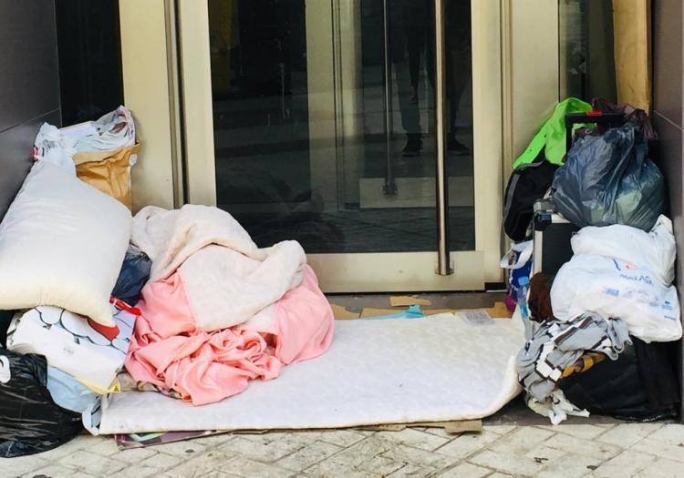 Imagen de archivo de mantas de una persona sin hogar junto a un cajero.