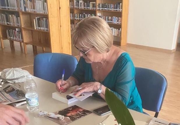 Purificación Guzmán firma uno de sus libros en la biblioteca del pueblo. 