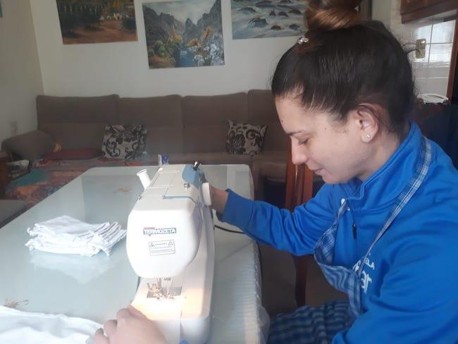 Una de las mujeres de la red cosiendo una mascarilla.