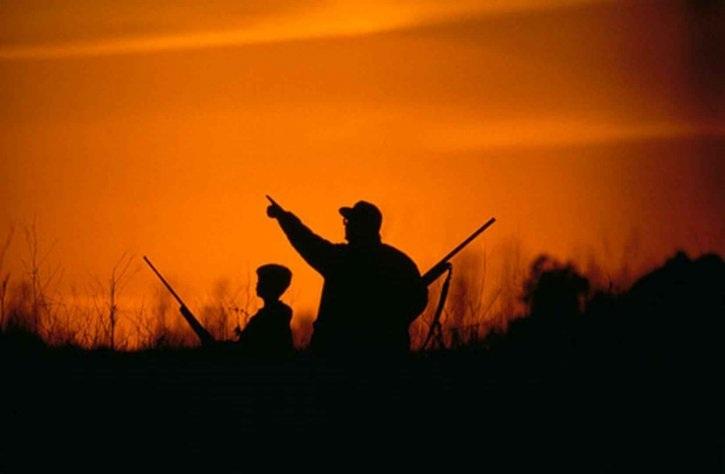 Un hombre y un menor practican la caza. 