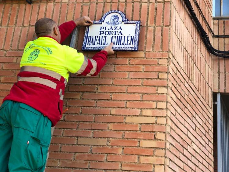 Un operario municipal coloca la placa con el nombre de Rafael Guillén.