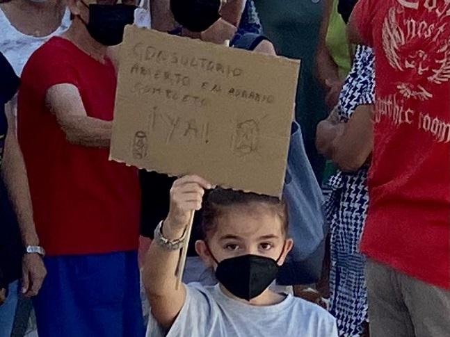 Una niña con una pancarta.