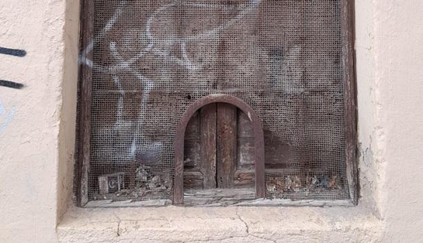 Detalle de la ventanilla de hace tres siglos, en la calle Ventanilla, deteriorada por decenas de años sin uso. 