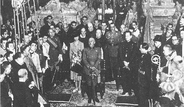 Franco, delante de las tumbas de los Reyes Católicos (mayo 1943), con las manos apoyadas en la espada.