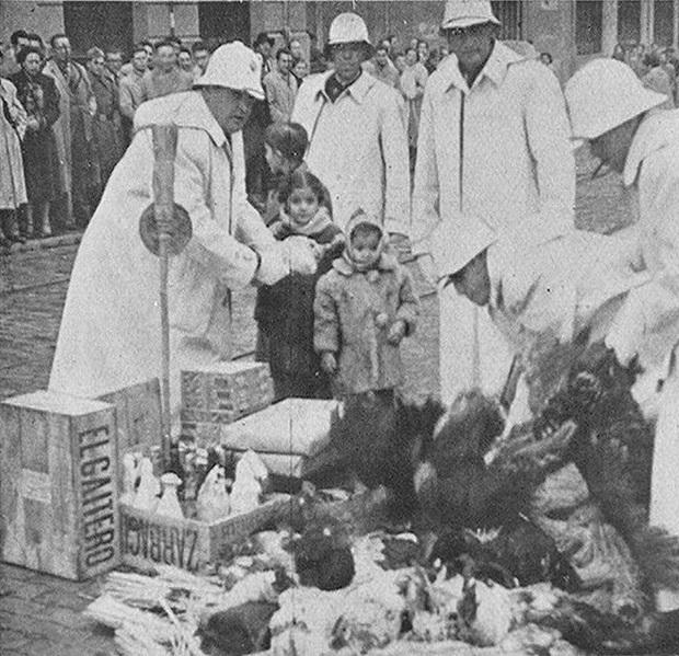 1 de enero de 1953: varios guardias reciben pavos, gallinas, bebidas, embutidos, etc. al inicio de Gran Vía.