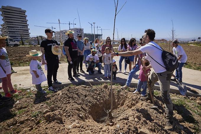 Personal de Covirán y sus familias plantan uno de los árboles. 