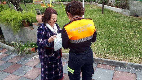 Una voluntaria de Protección Civil de Monachil entrega medicinas a una vecina del municipio.