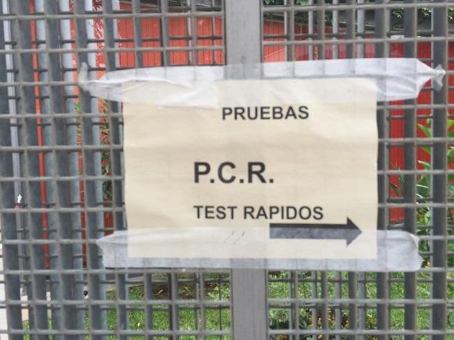 Cartel en un centro sanitario señalizando las pruebas PCR.