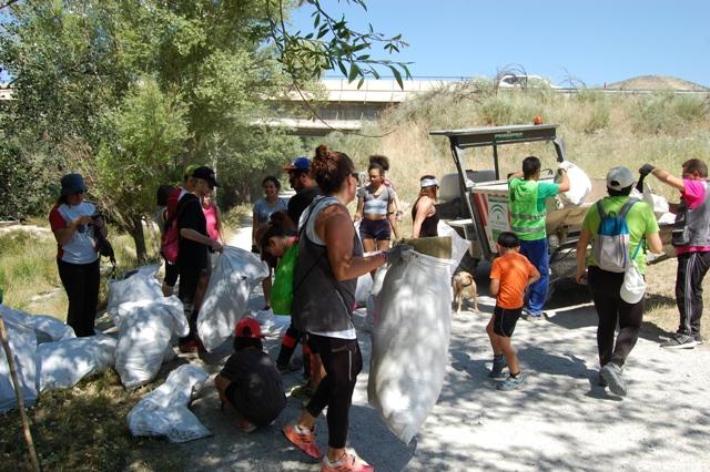 Voluntarios llevan bolsas con basura. 