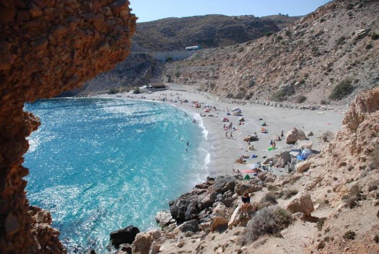 El agreste acceso a la playa de La Rijana impide tener a la vista los vehículos.