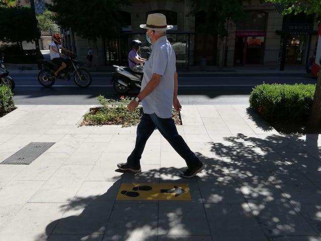 Un hombre pasea por Granada con mascarilla.