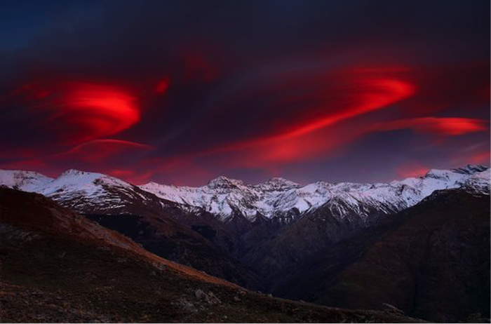 Sierra Nevada, en una bella puesta de sol que tiñe de rojo las nubes. 