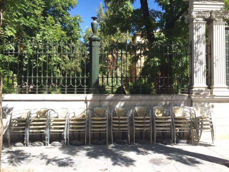 Sillas de una terraza apiladas en una plaza.