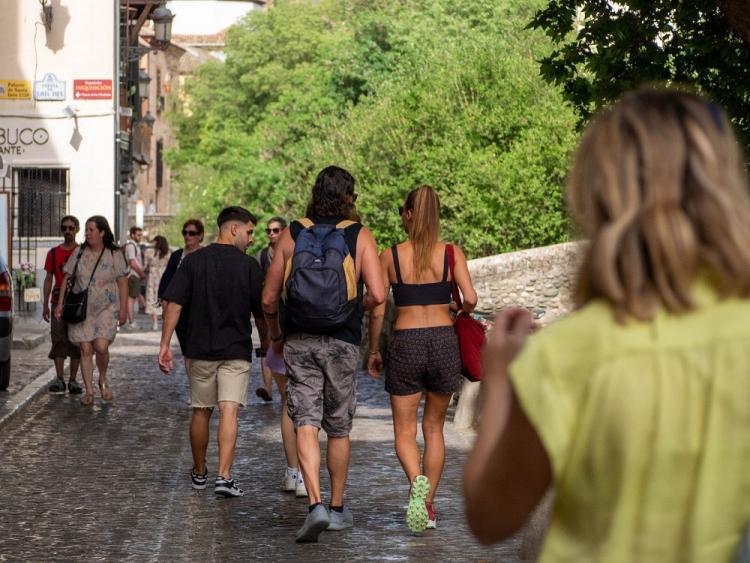 Turistas por la Carrera del Darro, una de las calles donde mejor se soportan las altas temperaturas en Granada.
