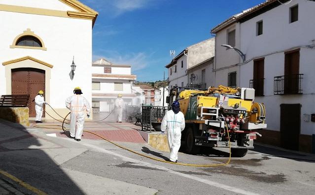 Efectivos del Infoca usan vehículos de extinción para desinfectar una plaza en Marchal.