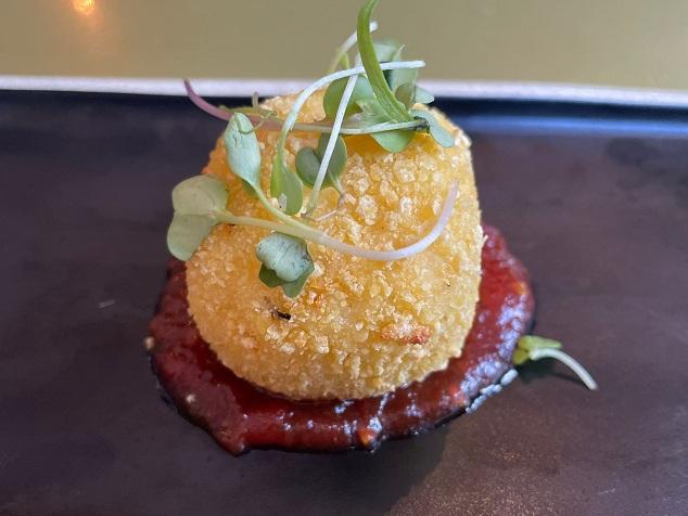 Bomba de patata morada rellena de crema de trufa y mermelada de tomate sin gluten, una de las tapas que se ofrecen en Granada.