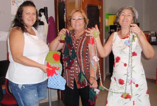 Participantes en el taller con las prendas de ganchillo.