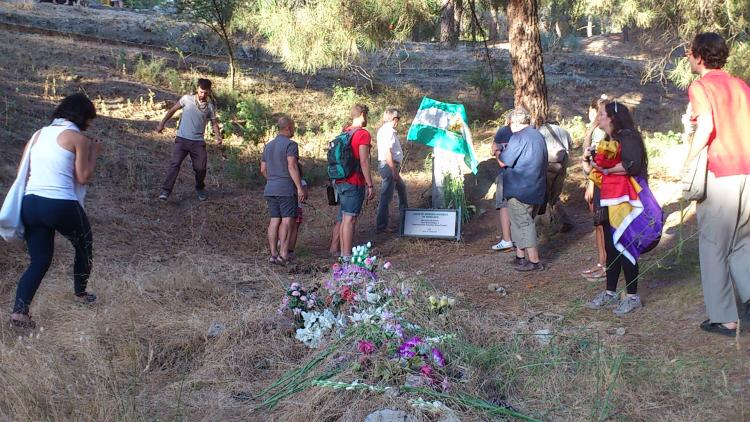 Los participantes ponen flores en la fosa de Víznar. 