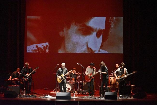 Un momento del concierto de El Hombre Garabato en el Teatro Isabel la Católica, con una gran imagen de Carlos Cano.