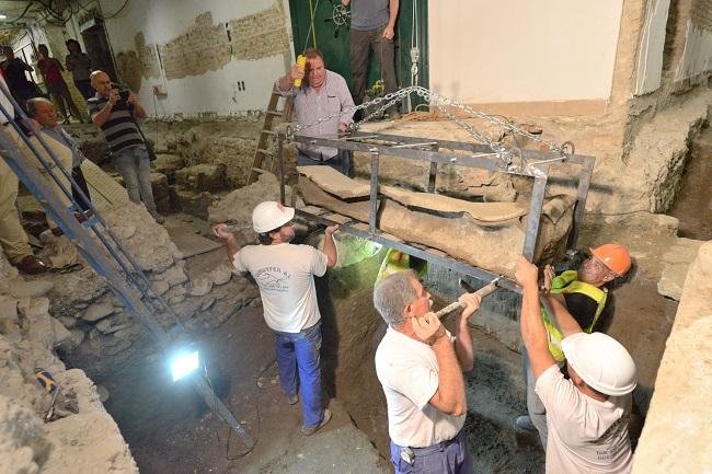 Operarios levantan el sarcófago para su traslado al Arqueológico.