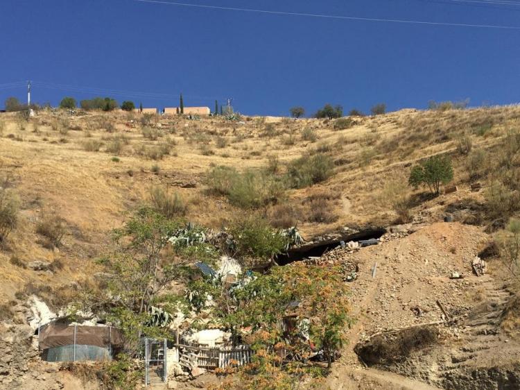 Ladera entre el cementerio y la Avenida Santa María de la Alhambra en la que se ven construcciones asociadas a una cueva.