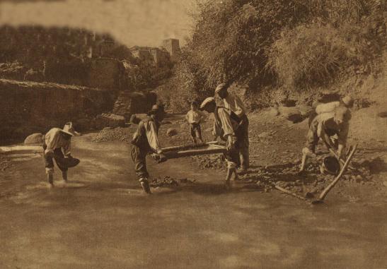 Lavadores de arenas de oro en el río Darro, por debajo del Sacromonte. Al fondo aparece la Alhambra. Esta foto fue hecha en 1930 y publicada en un periódico de Madrid.