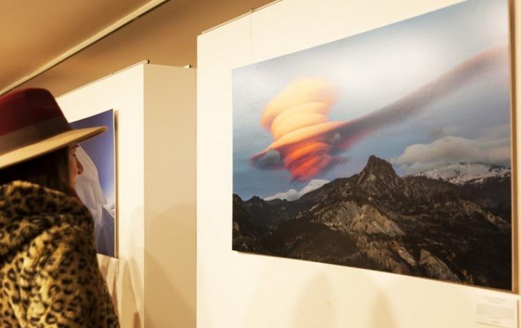 Una mujer observa un foto de una espectacular nube lenticular junto al pico Trevenque. 