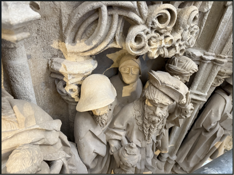 El espía situado en el cuadro de la derecha (centro de la imagen), embozado hasta la nariz, tras la figura de un rey mago y sus pajes. Imposible verlo desde el suelo ni de frente al conjunto.