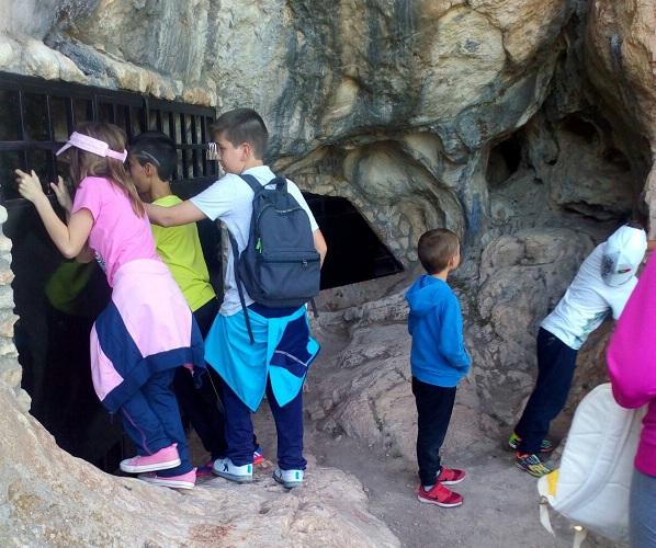 Niños se asoman a las cavidades de la cueva. 