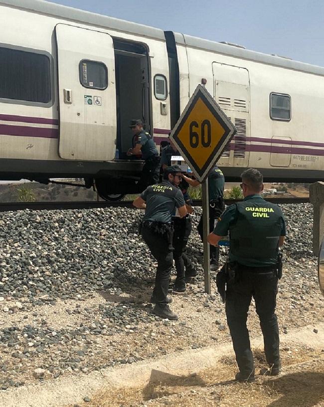 Agentes de la Guardia Civil durante el abastecimiento de agua al pasaje del tren detenido en Alamedilla.