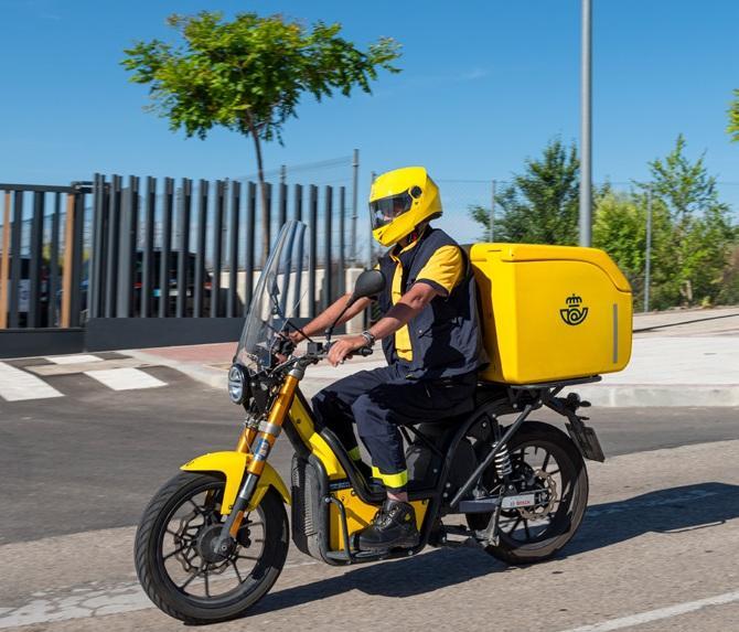 Cartero de Correos durante un reparto en moto. 