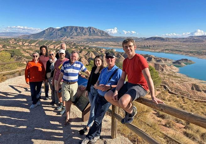 Responsables de agencias de viajes, junto al pantano del Negratín, con el cerro Jabalcón al fondo, cuyo paisaje puede verse alterado por un parque eólico en la cima y las tuberías de una central hidroeléctrica de bombeo.