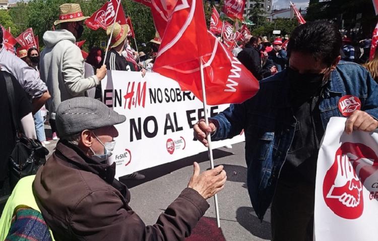 Un hombre mayor en silla de ruedas coge una bandera sindical este viernes en la manifestación del Primero de Mayo en Granada.