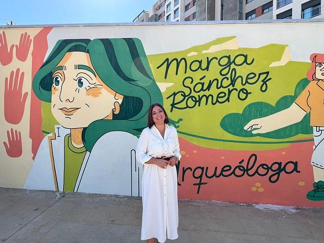 Marga Sánchez Romero, junto al mural que le han dedicado.
