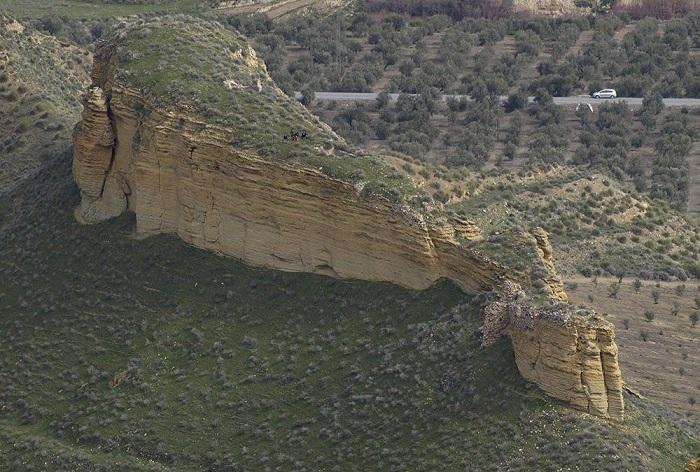 Roca sobre la que se asentó el castillo de Al-Liqun, vista desde el Suroeste. Se aprecia el acceso en la parte inferior derecha. Roca sobre la que se asentó el castillo de Al-Liqun, vista desde el Suroeste. Se aprecia el acceso en la parte inferior derecha.