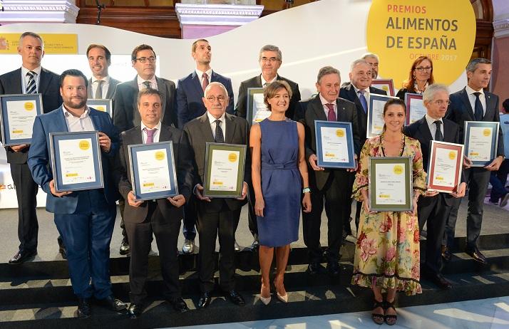 La representante de Venchipa, en primer término junto a la ministra, muestra su galardón junto al resto de premiados.