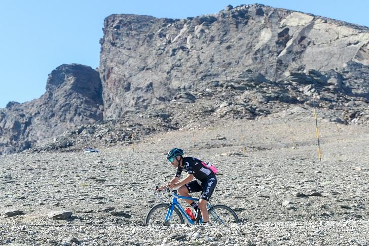 Un ciclista con el emblemático pico Veleta detrás. 