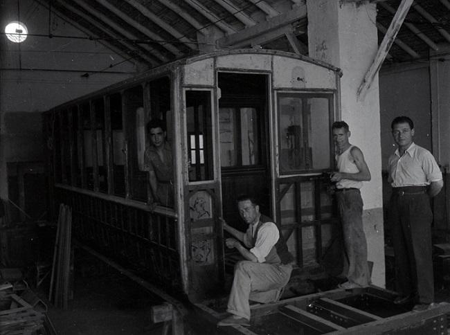 Trabajadores del taller de Puente Verde con un tranvía en proceso de recarrozado, enero de 1943. 