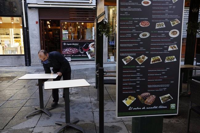 Un camarero prepara una terraza de hostelería en Granada. 