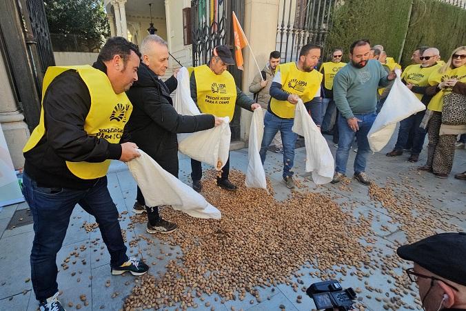 Agricultores tiran almendras al suelo en la puerta de la Subdelegación del Gobierno. 