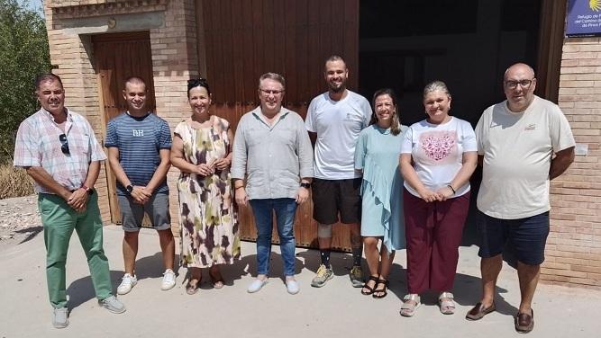 Jorge Mora, con camiseta blanca, junto a responsables municipales de Pinos Puente, en la puerta del albergue del peregrino. 