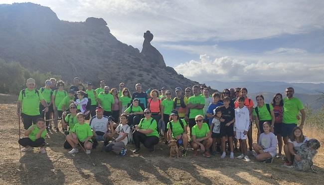 vecinos y miembros de la Asociación "Corro por Marina y Samuel", frente a la formación natural de piedra "El Cerro del Fraile", uno de los símbolos de la localidad de Beas de Granada.
