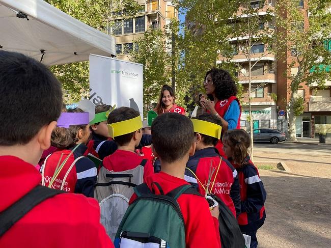 Voluntarias de la Cruz Roja de Granada, con niñas y niños, en uno de los talleres.