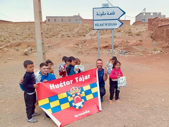 Antonio Sillero y Jorge García, con la bandera de Huétor Tájar, junto a niñas y niños marroquíes.