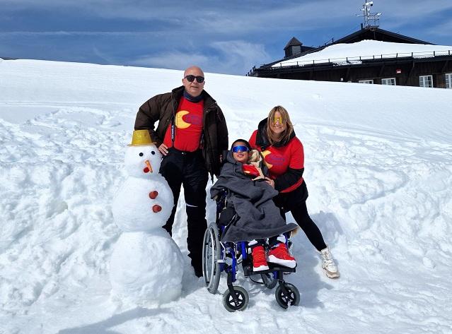 Walter, con su cara de felicidad al conocer la nieve en Sierra Nevada, con personal voluntario de la asociación.