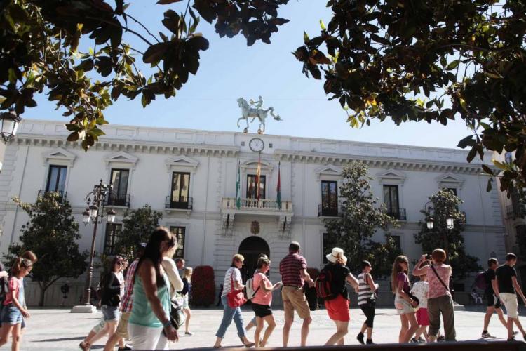 Turistas pasan frente al Ayuntamiento de Granada.