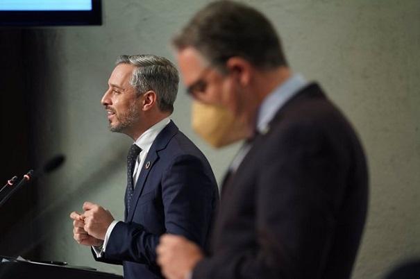 El consejero Juan Bravo, junto a Elías Bendodo, al presentar el decreto.